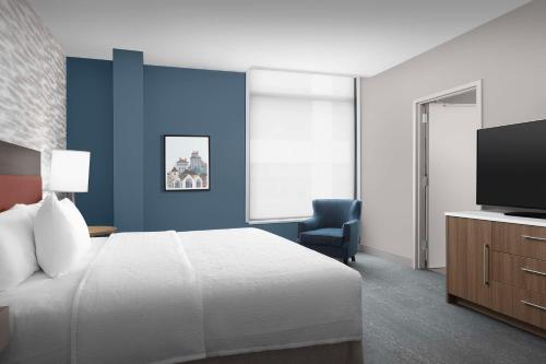 a hotel room with a bed and a television at Home2 Suites By Hilton Falls Church in Falls Church