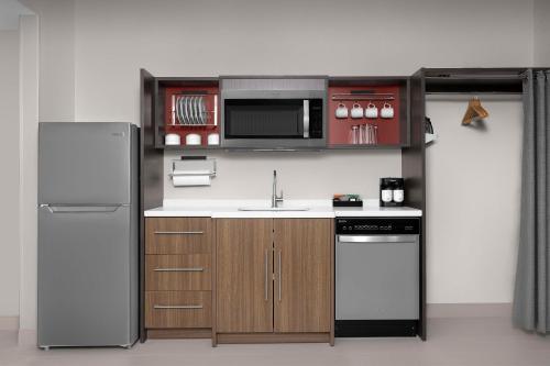 a small kitchen with a sink and a refrigerator at Home2 Suites By Hilton Falls Church in Falls Church