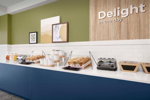 a bakery counter with pastries and a sign that reads delight in the day at Spark By Hilton San Antonio Northwest Near Six Flags in San Antonio