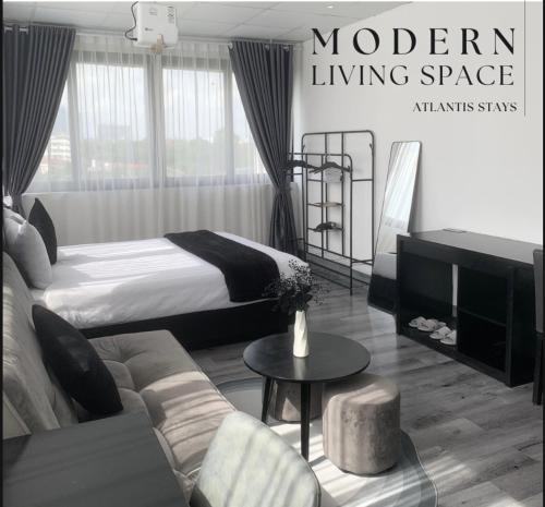 a hotel room with a bed and a living space at Atlantis Apartment Nguyen Thai Hoc in Hanoi