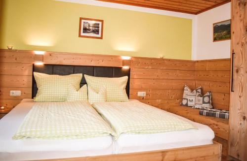 een slaapkamer met een groot bed met een houten hoofdeinde bij Urlaub auf dem Haberlhof in Lohberg