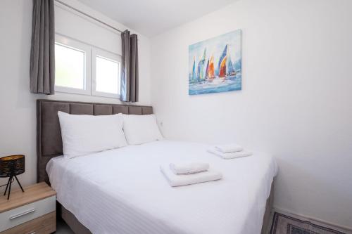 a bedroom with a white bed with two towels on it at Lucky Bay - Comfort & Terrace Vibes in Mlini
