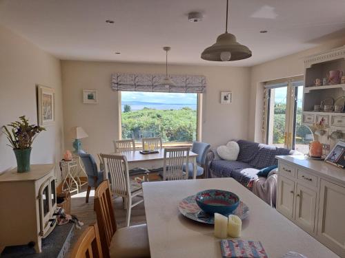 eine Küche und ein Wohnzimmer mit einem Tisch und einer Couch in der Unterkunft Sioscadh na Mara in Spiddal