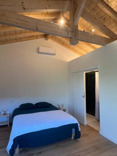 une chambre avec un lit et un plafond en bois dans l'établissement Maison en première ligne port de La Teste de Buch, à La Teste-de-Buch