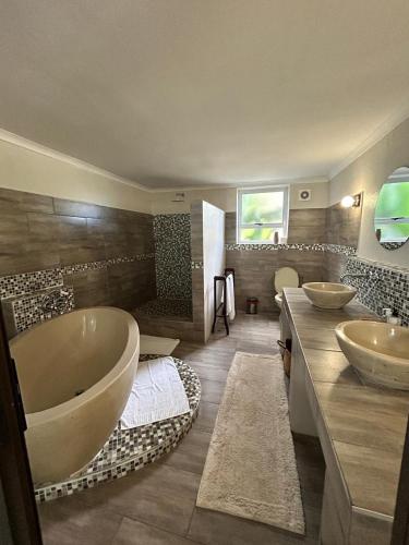 ネルスプロイトにあるCalla Lily Guesthouseのバスルーム(シンク2台、大型バスタブ付)