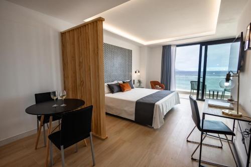 une chambre avec un lit et une table avec des chaises dans l'établissement Matilde Luxury by Grupo Matilde, à Las Palmas de Gran Canaria