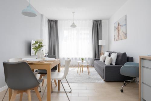 a living room with a table and a couch at Metro Targówek One Bedroom Apartment for 4 with Furnished Balcony by Noclegi Renters in Warsaw