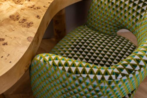 a green chair sitting next to a wooden table at The Couper Umiltà in Rome