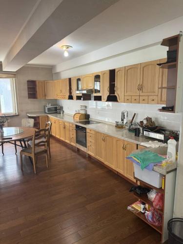 a kitchen with wooden cabinets and a table in it at Guest House Ulaanbaatar in Ulaanbaatar