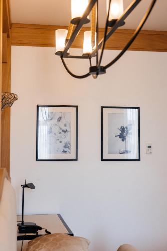 a living room with two pictures and a chandelier at Shirvanshah Hotel in Baku