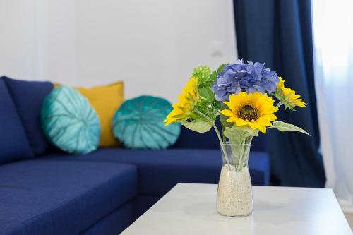 a vase filled with blue and yellow flowers on a table at Plaza Caballo 3 Dormitorios Vistas in Jerez de la Frontera