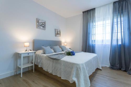 a white bedroom with a bed and a window at Plaza Caballo 3 Dormitorios Vistas in Jerez de la Frontera
