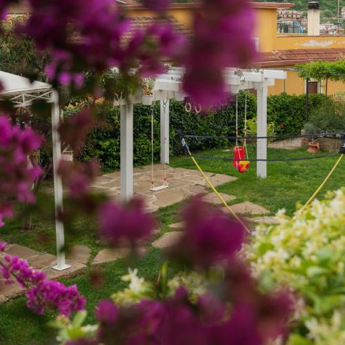 a garden with a swing and purple flowers at Casa Vittoria in Agropoli