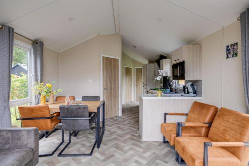 a kitchen and living room with a table and chairs at Modern chalet op de Veluwe in Epe