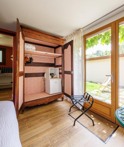 Cette chambre comprend un lit, une fenêtre et une chaise. dans l'établissement Moulin de Retord, côté étang - Chambres d'hôtes, à Pérassay