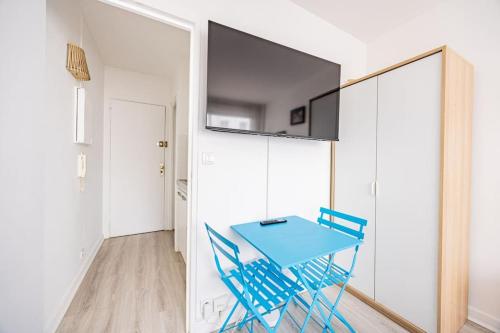 une salle à manger avec une table et des chaises bleues dans l'établissement Studio Rénové 2 pers République Bastille Paris 11, à Paris