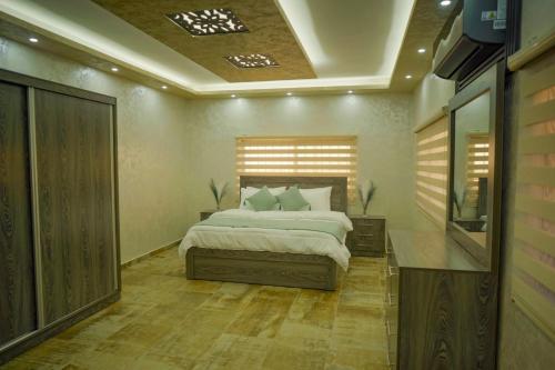 a bedroom with a bed and a television in it at Tallet falastin in Umm Juraysāt