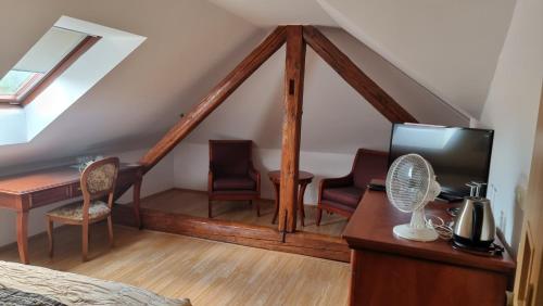 a attic room with a bed and a desk at Penzion u dobrého lva in Frenštát pod Radhoštěm