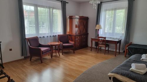 a living room with a table and chairs and a desk at Penzion u dobrého lva in Frenštát pod Radhoštěm