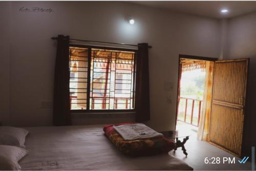 a bedroom with a bed and a large window at Kopai View in Bolpur