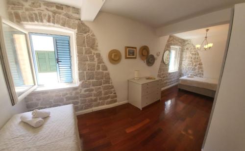 a bedroom with a stone wall and a bed and window at Apartments Villa De Blue in Bol