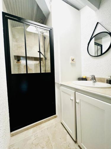 La salle de bains est pourvue d'une porte noire et d'un lavabo. dans l'établissement Renovated 2 bedroom duplex apartment in the center of Antibes, à Antibes