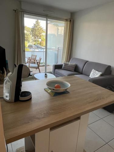 un salon avec une table avec un bol dessus dans l'établissement Appartement lumineux climatisé avec terrasse, à La Ciotat
