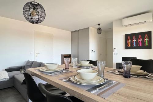 - une table à manger avec des assiettes et des bols dans l'établissement Appartement Le 202 - Tain l'Hermitage, à Tain-lʼHermitage