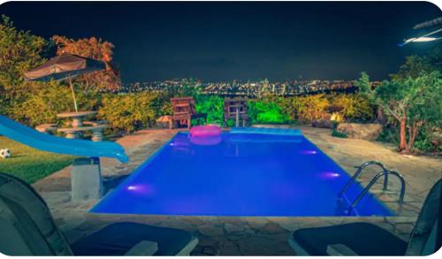 a swimming pool in a backyard at night at Casa de Pedras na Montanha Stone House in Atibaia