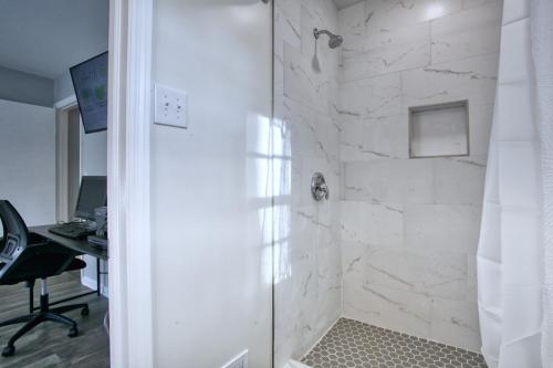 a white bathroom with a shower with a desk at Rocksteady Atlanta Decatur in Decatur