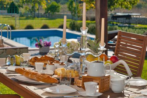 a table with a breakfast of bread and fruit next to a pool at Luxury Villa Luminosa in Split