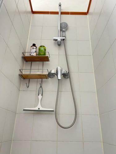 une douche avec pommeau de douche dans une salle de bain dans l'établissement Magnifique 2p avec vue sur le Sacré Coeur, à Paris