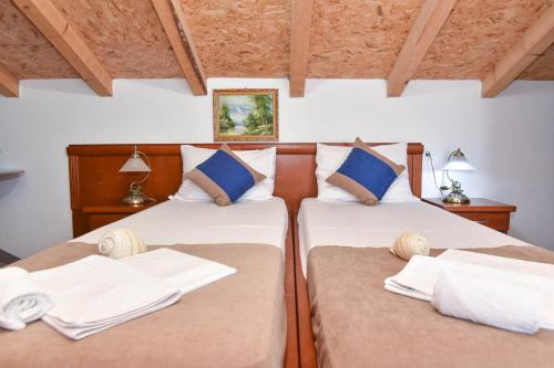 two beds in a room with two pillows at Villa Pedja Zec in Budva