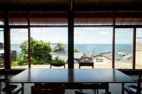 a table and chairs in front of a large window at 点景 tenkei in Gamō