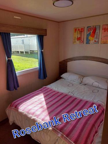 a small bedroom with a bed with a window at Rose bank Retreat in Hunmanby