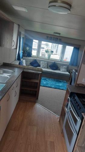 a kitchen with a couch in the middle of a room at Rose bank Retreat in Hunmanby