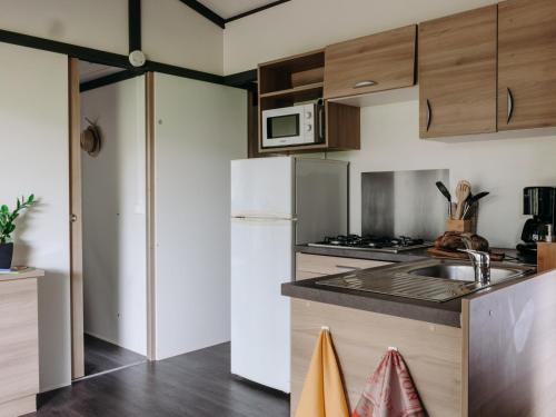a kitchen with a sink and a refrigerator at Slow Village Anduze - Cévennes in Corbés