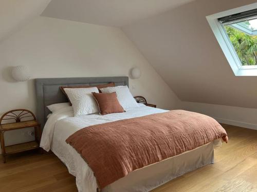 une chambre avec un lit et une fenêtre dans l'établissement Belle maison de vacances proche de la plage, à Combrit