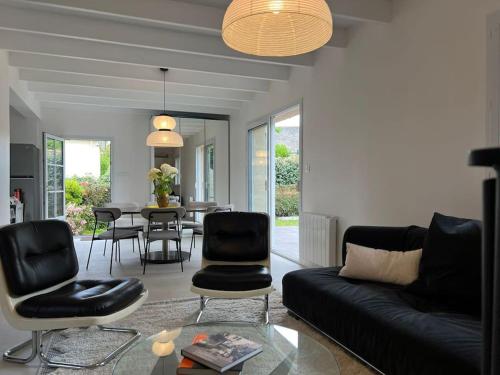 un salon avec un canapé, des chaises et une table dans l'établissement Belle maison de vacances proche de la plage, à Combrit