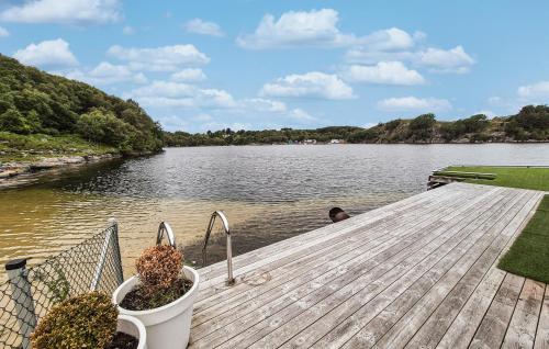 a man sitting on a dock in the water at 2 Bedroom Lovely Home In Haugesund in Haugesund