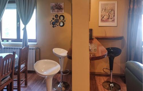 a kitchen with a table and stools in a room at Amazing Home In Velika Mlaka With Wifi in Velika Mlaka