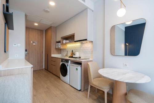 a kitchen with a washing machine and a table at Staybridge Suites Bangkok Thonglor by IHG in Bangkok