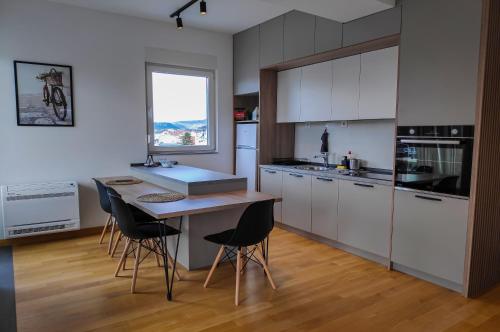 a kitchen with white cabinets and a table and chairs at Golden View Apartment in Ohrid