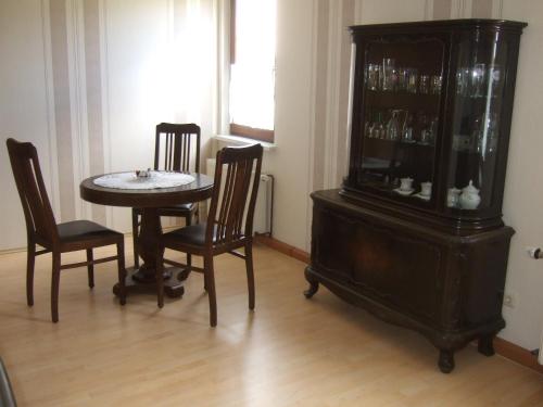 een eetkamer met een tafel en stoelen en een kast bij Fewo im Neuseenland 2 in Rötha