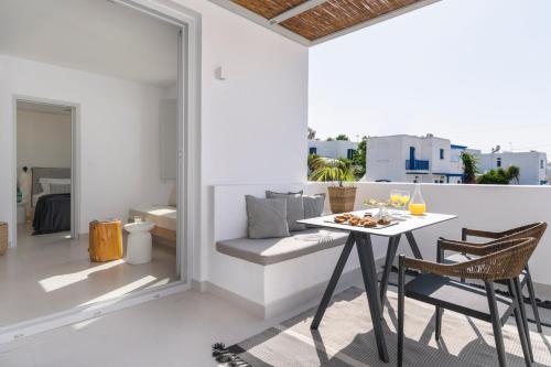 a dining room with a table and chairs on a balcony at Quartano Suites by Heliessa, Adults Only in Naousa