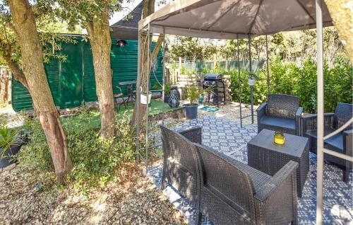 un patio avec une table et des chaises sous un parasol dans l'établissement Gorgeous StaCaravan, à Pernes-les-Fontaines