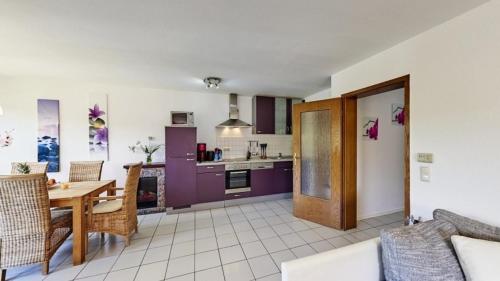 Una sala de estar con una mesa y una cocina. en Ferienwohnung Seeblick I, en Schalkenmehren
