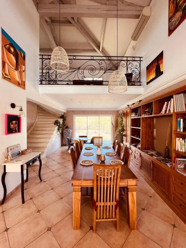 une salle à manger avec une table et des chaises en bois dans l'établissement Villa spacieuse avec pisicne, à Villetelle