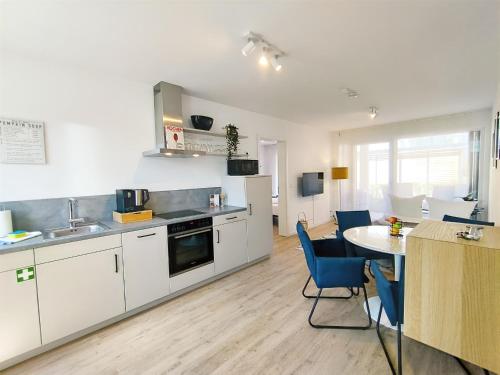 a kitchen with white cabinets and a table and chairs at CityVibe Apartment für bis zu 4 in Erlangen