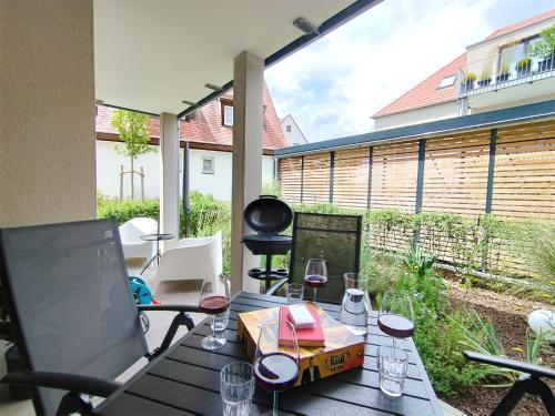 a table with glasses of wine on a patio at CityVibe Apartment für bis zu 4 in Erlangen